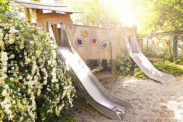 Kita Kleine Knöpfe. Im Garten mit zwei Rutschen