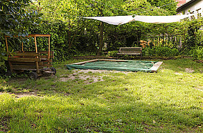 Der Garten mit überdachtem Sandkasten in der Kita Kleine Knöpfe