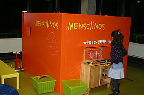 Ein Kind steht in der Mensa im Bereich der Mensalinos